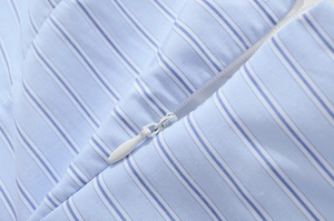 Detailed macro shot of the high-quality invisible zipper on a blue striped cotton dress