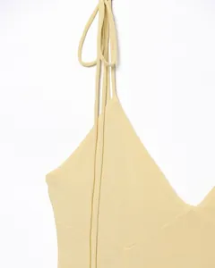 Détail des fines bretelles et du décolleté en V sur la robe tricotée jaune clair