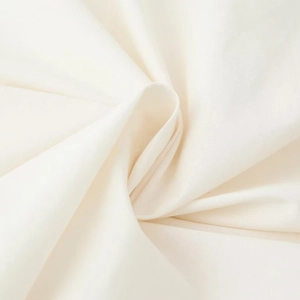 Close-up of beige woven fabric dress showing cotton linen texture and soft draping effect