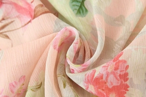 Detailed close-up of floral print chiffon fabric with soft pink flowers and micro-wrinkles