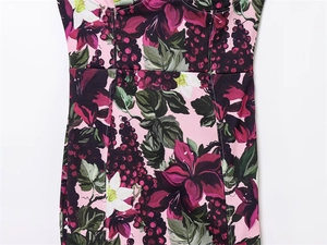 Détail de motifs floraux et de raisins sur robe moulante de printemps en rose tendre