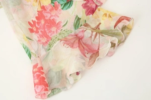 Detailed close-up of ruffle cuffs on floral print chiffon top for spring 2025 fashion