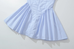 Detailed close-up of light blue striped dress showing pleated stitching and fabric texture