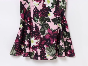 Détail de l'imprimé floral et raisin sur tissu de robe rose avec coutures soignées