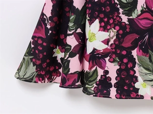 Gros plan sur un tissu rose clair avec motifs de raisins violets et de fleurs