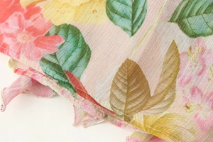 Detail of floral chiffon fabric showing pink flowers and precise stitching craftsmanship