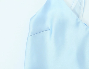 Detail of light blue satin dress featuring a V-neckline and precise bust dart stitching
