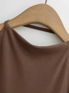 Détail du décolleté de robe en maille marron foncé avec fines bretelles et texture