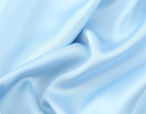 Detail of light blue silk satin fabric showing smooth texture and elegant drape