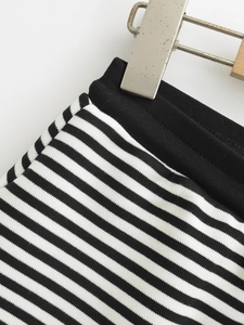 Détail d'un short à rayures noires et blanches avec une taille élastique en tricot noir