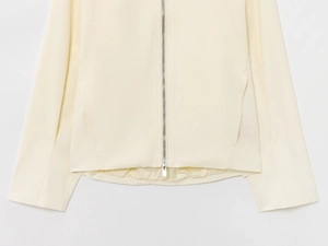 Close-up of premium cream wool bomber jacket featuring metallic silver zipper and satin lining