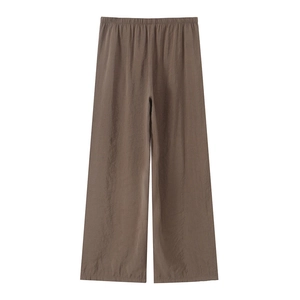 Detail of dark brown wide-leg pants featuring an elastic waistband and textured fabric