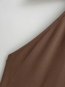 Vue détaillée de la texture du tissu marron avec coutures précises sur une robe