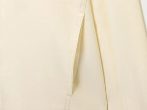Macro shot of precise stitching on beige wool bomber jacket pocket and woven fabric texture