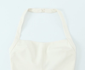 Détail du haut dos nu blanc avec fermeture à double bouton et coutures à pinces