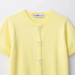 Short sleeve knit top in yellow with pearl bow buttons and ribbed crew neck finish