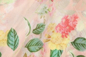 Close-up of floral print chiffon fabric with soft pink blooms and subtle vertical texture