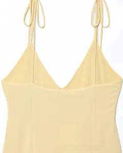Détail des doubles bretelles réglables et du col en V sur une robe en mousseline jaune