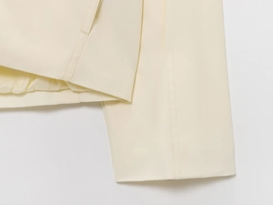 Close-up of cream bomber jacket featuring twill texture and glossy satin lining