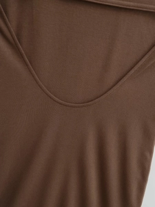 Détail de la texture en maille marron et des coutures lisses de l'encolure de la robe