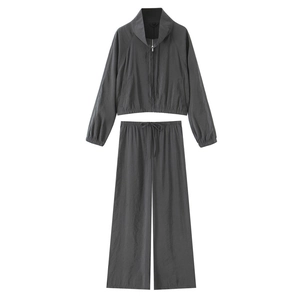 Detailed close-up of dark grey two-piece casual tracksuit with zip-up jacket and wide pants