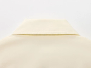 Detailed close-up of cream bomber jacket collar showing premium double stitching and texture