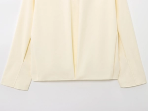 Detailed macro view showing the clean stitching on the cream bomber jacket cuff and hem