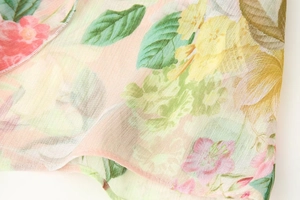 Close-up of floral print chiffon fabric with delicate pink flowers and stitched edge
