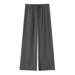 Detail of dark grey wide-leg trousers featuring an elastic waistband and drawstring detail