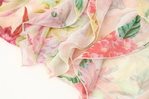 Detail of floral chiffon fabric with layered ruffles and colorful flower patterns