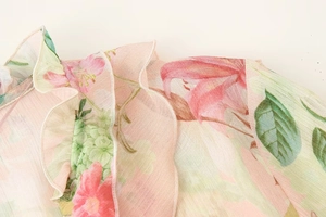 Close-up of pink floral print chiffon blouse with delicate layered ruffle neckline details
