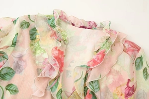 Detailed close-up of pink floral chiffon top with layered ruffles and textured finish