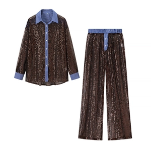Détail de l'ensemble pailleté bronze avec contraste rayé bleu sur le col et poignets