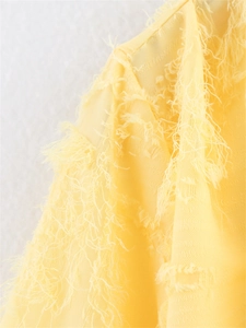 Gros plan détaillé du tissu en maille jaune vif avec franges bohèmes et fibres douces