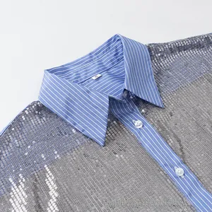 Vue macro d'un chemisier à paillettes argentées avec col à rayures bleues détaillé