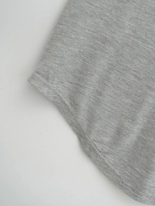 Detail view of heather grey knit fabric with curved hem and durable double-needle stitching