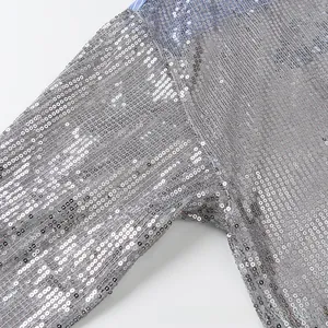 Détail du tissu à paillettes argentées sur haut à manches longues avec doublure rayée