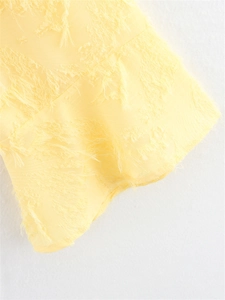Détail rapproché du tissu jaune clair avec franges texturées et design de gland 3D
