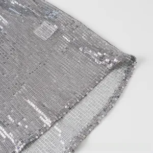 Détail de paillettes argentées sur tissu mesh avec coutures et bords de qualité