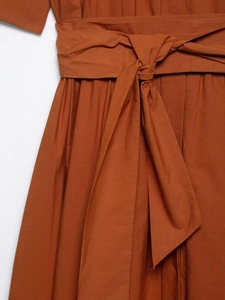 Detailed view of women's reddish brown poplin dress featuring a waist tie bow detail