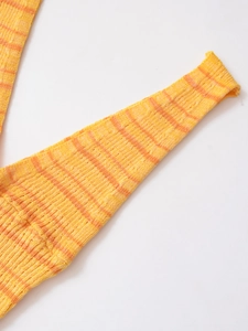 Détail rapproché d'un tissu en maille rayé jaune et orange avec texture côtelée fine