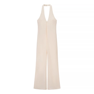 Detail of light beige halter neck jumpsuit with deep V-neckline and wide-leg trousers