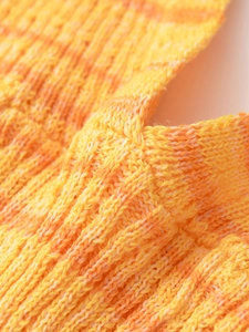 Vue macro de maille côtelée verticale en dégradé de jaune vif, orange et blanc