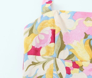 Détail de la robe à fleurs dos nu montrant le tissu en coton texturé et l'encolure carrée