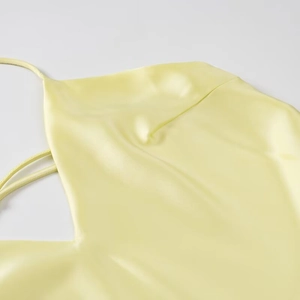 Elegant light yellow satin slip midi dress with thin straps and a silky glossy finish