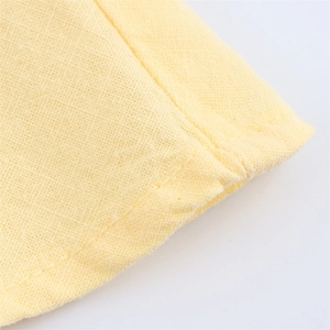 Macro shot of yellow ramie blend fabric showing fine woven texture and neat stitching