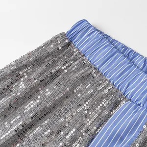 Détail de la taille élastique à rayures bleues avec paillettes argentées sur le pantalon