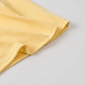 Gros plan sur les coutures précises à double aiguille du bord en tricot jaune