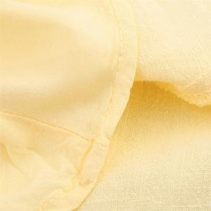 Macro detail of cream linen blend fabric with precise curved stitching and natural texture