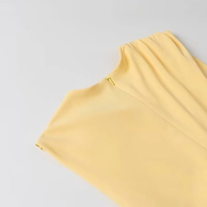Détail de l'encolure arrière avec fermeture éclair invisible sur une robe jaune pâle